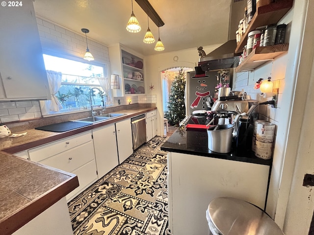 kitchen with tasteful backsplash, stainless steel dishwasher, sink, decorative light fixtures, and white cabinets