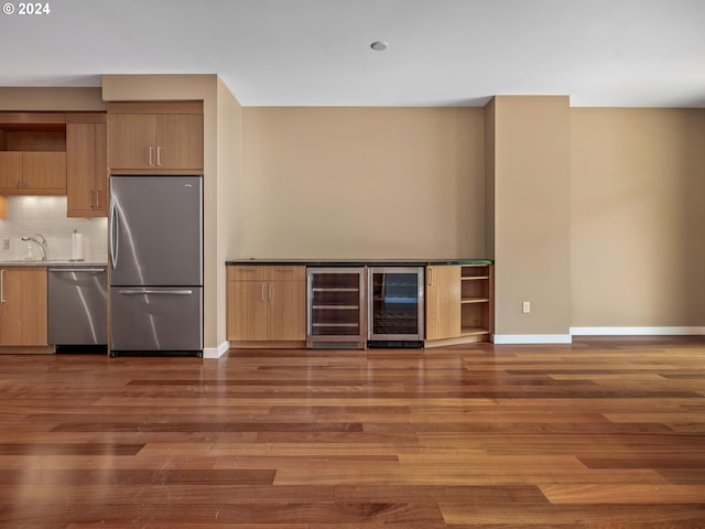 kitchen featuring appliances with stainless steel finishes, dark hardwood / wood-style floors, sink, and beverage cooler