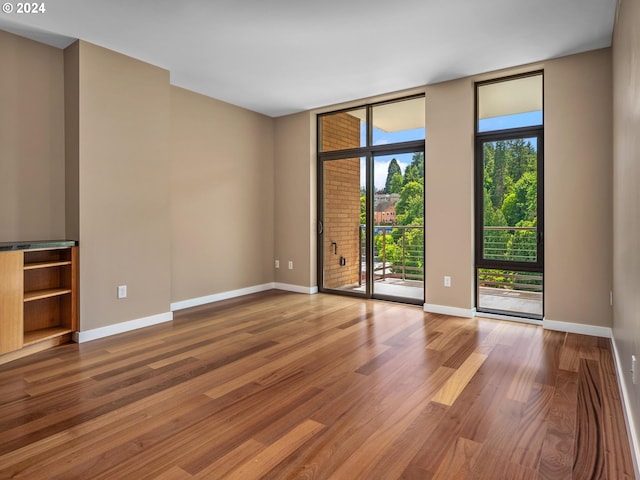 spare room with hardwood / wood-style floors and floor to ceiling windows