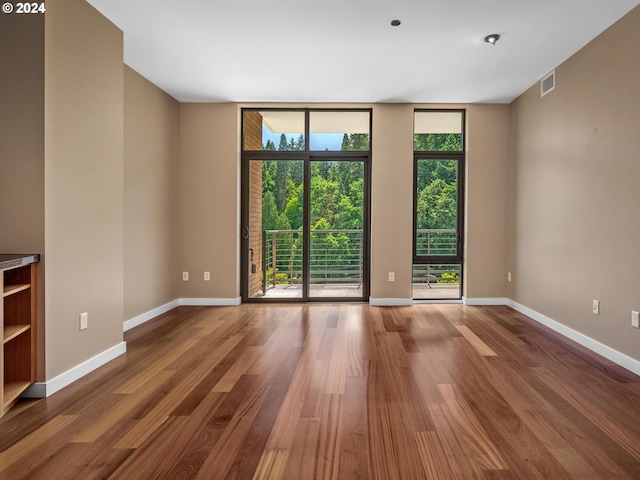 unfurnished room featuring wood-type flooring and expansive windows