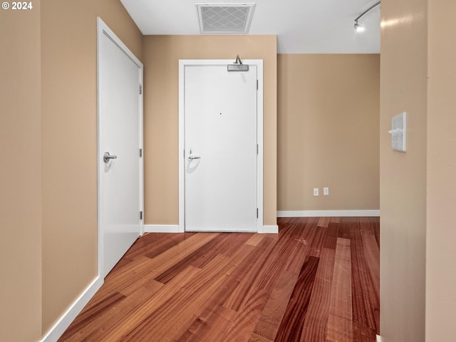 interior space with hardwood / wood-style floors and rail lighting