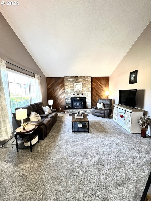 living room featuring carpet floors, wood walls, vaulted ceiling, and a wood stove