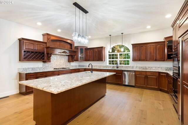 kitchen with decorative light fixtures, appliances with stainless steel finishes, light wood-type flooring, and open shelves