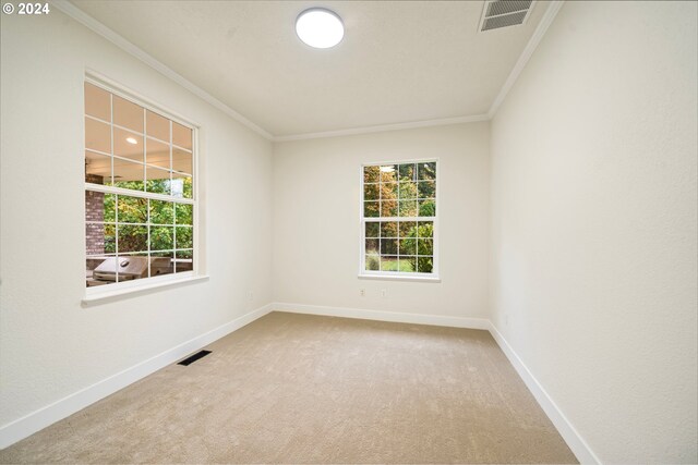 carpeted empty room featuring visible vents, baseboards, and ornamental molding