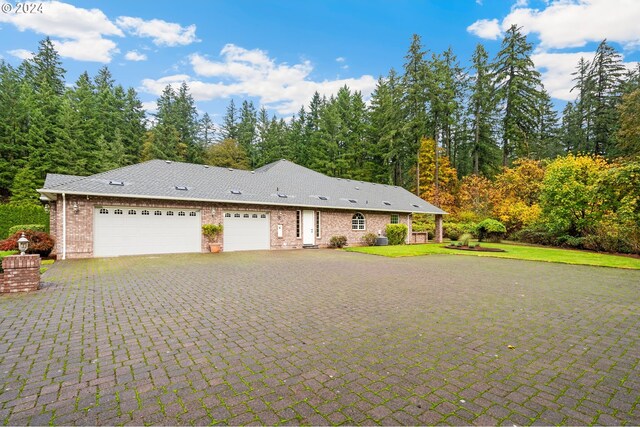 view of front of property featuring aphalt driveway, an attached garage, brick siding, and a front yard