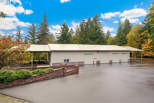 exterior space featuring an outbuilding, metal roof, and a detached garage