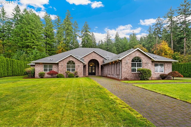 single story home with brick siding, a front lawn, and driveway