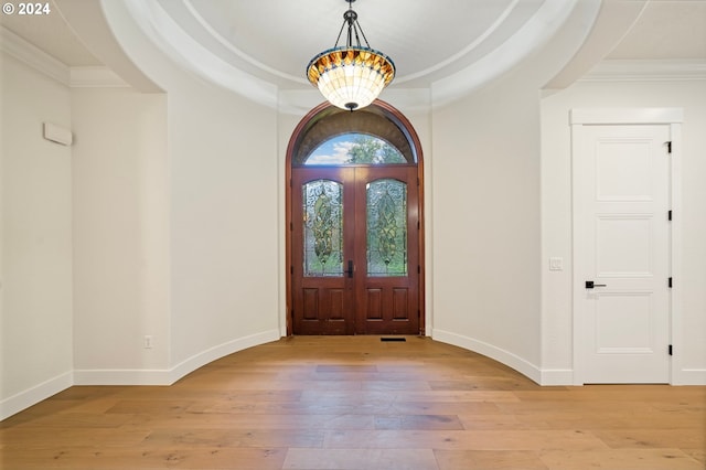 entrance foyer with baseboards, light wood-type flooring, french doors, and ornamental molding