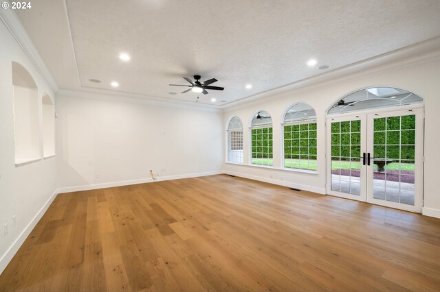 spare room with baseboards, light wood-style floors, and ornamental molding