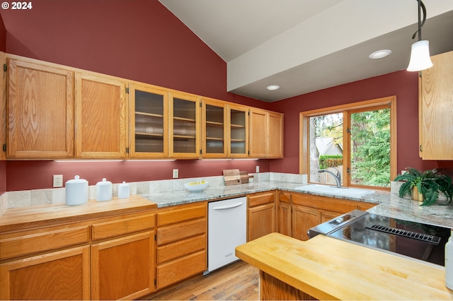 kitchen with lofted ceiling, hanging light fixtures, stove, light hardwood / wood-style floors, and sink