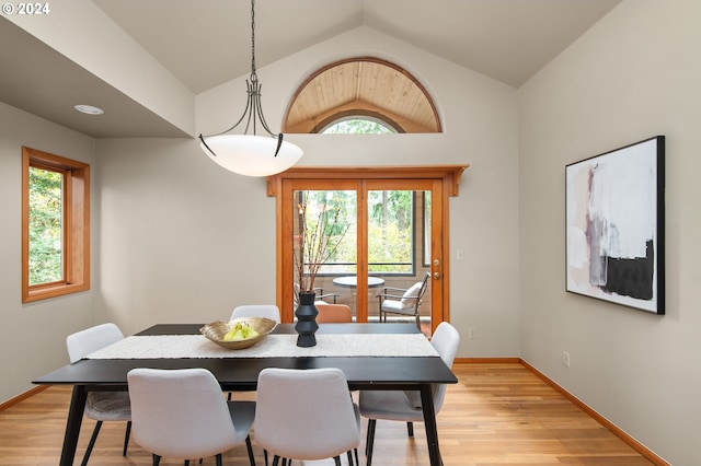 dining area featuring a healthy amount of sunlight, lofted ceiling, and light wood-type flooring