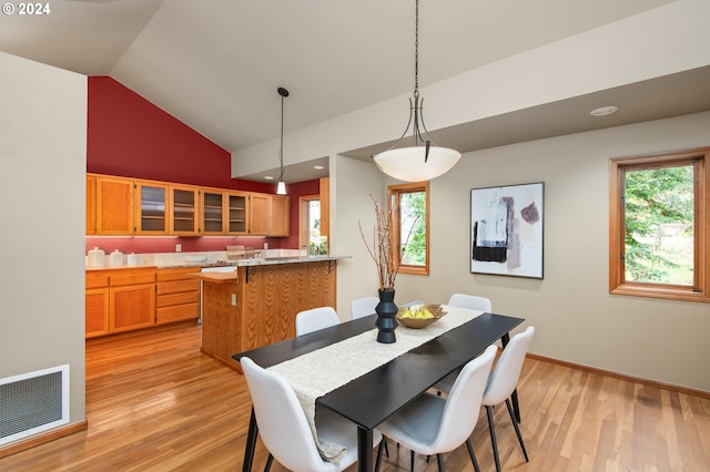 dining room with light hardwood / wood-style floors and lofted ceiling