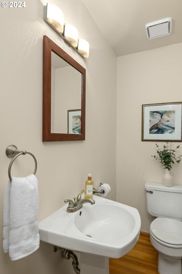 bathroom with toilet, hardwood / wood-style flooring, and sink