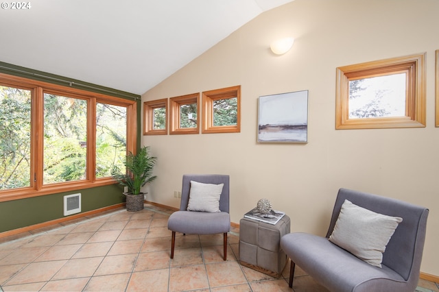 living area featuring vaulted ceiling and light tile patterned floors