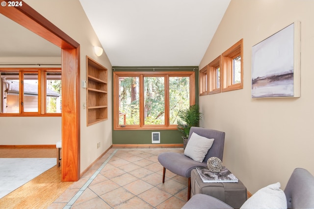 living area featuring light tile patterned flooring, built in features, and lofted ceiling