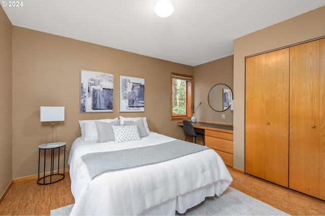 bedroom featuring a closet, built in desk, and carpet flooring