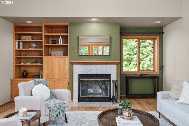 living room with light wood-type flooring and a tile fireplace