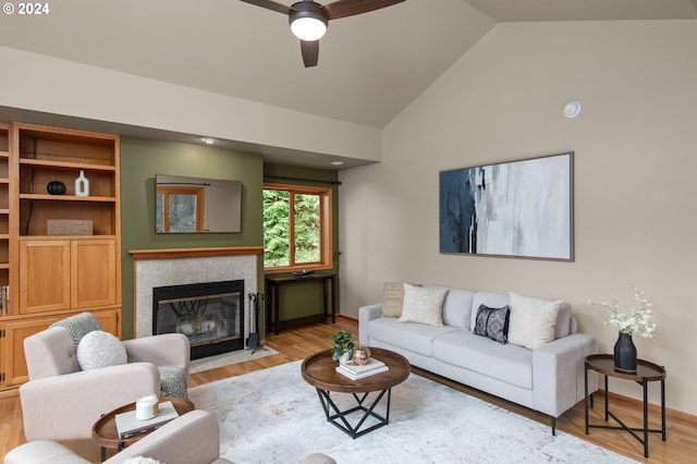 living room featuring light hardwood / wood-style floors, high vaulted ceiling, and ceiling fan