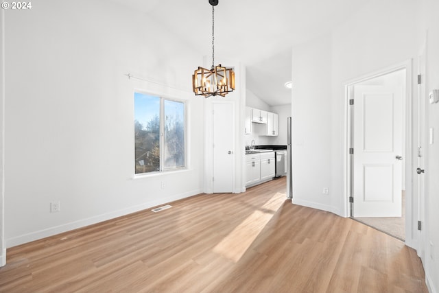 unfurnished living room with light wood-type flooring, sink, high vaulted ceiling, and an inviting chandelier