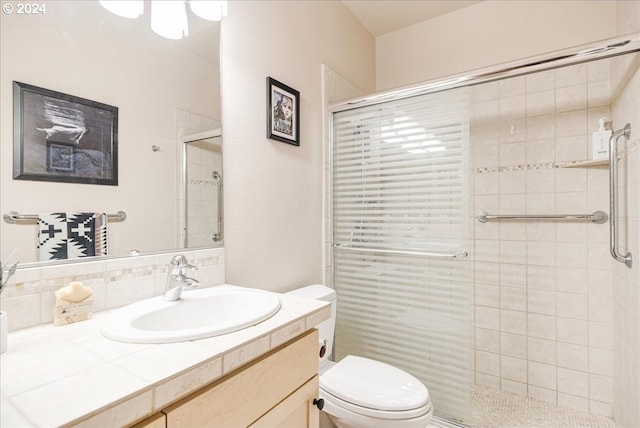 bathroom featuring vanity, toilet, and walk in shower