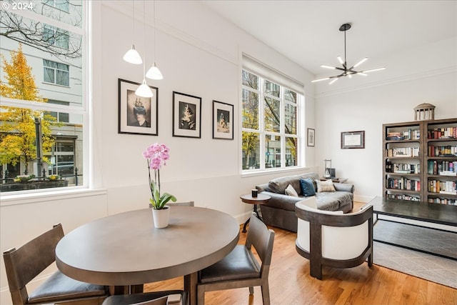 dining space with hardwood / wood-style floors and a notable chandelier