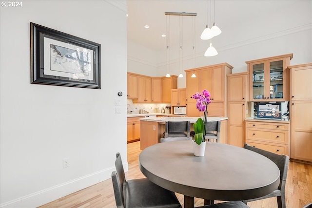 dining area with light hardwood / wood-style floors and ornamental molding