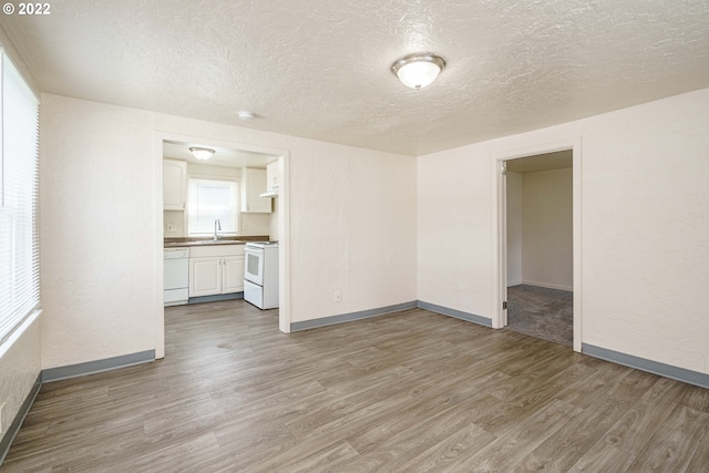 unfurnished room featuring a textured ceiling, sink, and hardwood / wood-style flooring