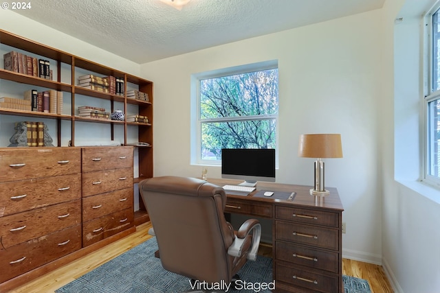 home office featuring a textured ceiling and light wood-type flooring