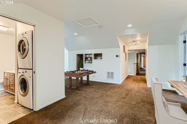 laundry area featuring stacked washing maching and dryer and light colored carpet