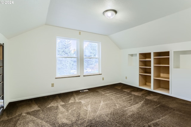 bonus room with lofted ceiling and carpet flooring