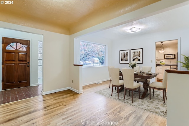 dining area featuring light hardwood / wood-style floors and a textured ceiling