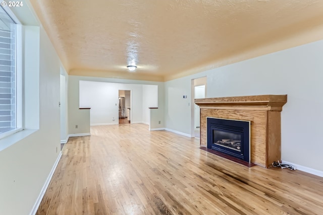 unfurnished living room featuring hardwood / wood-style floors and a textured ceiling