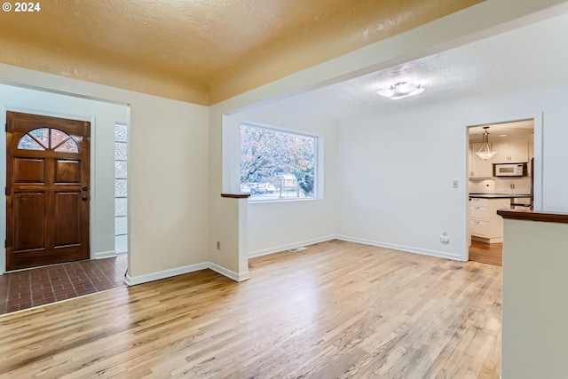 entrance foyer featuring light hardwood / wood-style floors and a textured ceiling