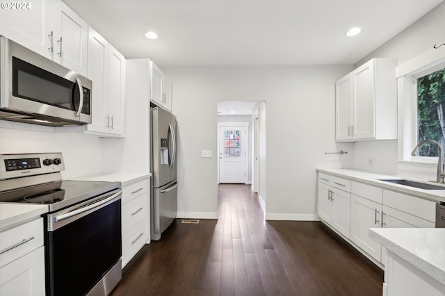 kitchen with stainless steel appliances, white cabinetry, plenty of natural light, and sink