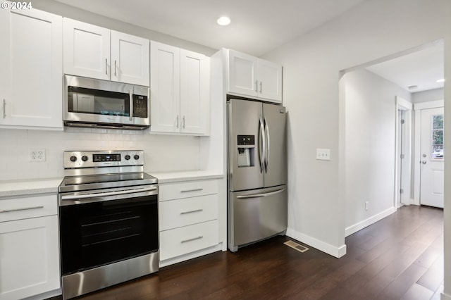 kitchen with tasteful backsplash, dark wood-type flooring, white cabinets, and stainless steel appliances