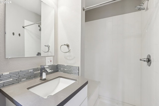 bathroom featuring backsplash, vanity, and a tile shower