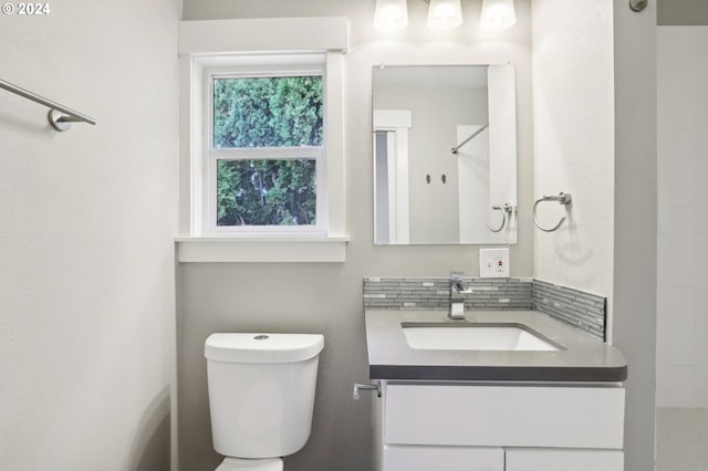 bathroom featuring vanity, toilet, and a shower