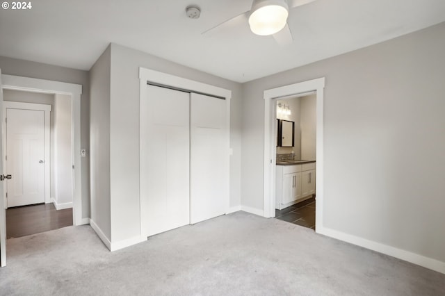 unfurnished bedroom featuring connected bathroom, carpet floors, a closet, and ceiling fan