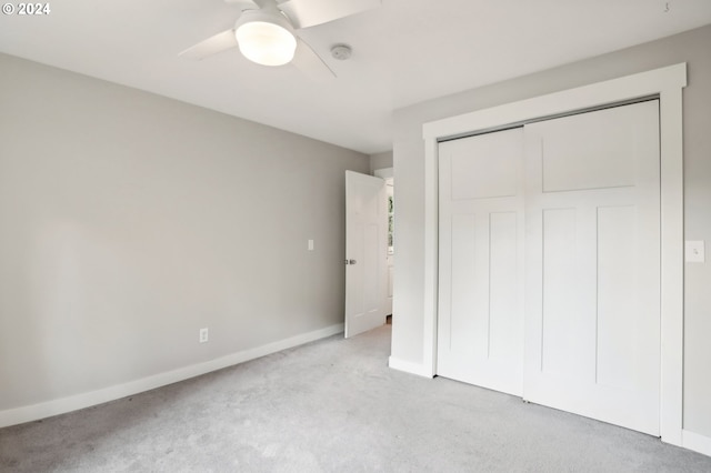 unfurnished bedroom with light carpet, a closet, and ceiling fan