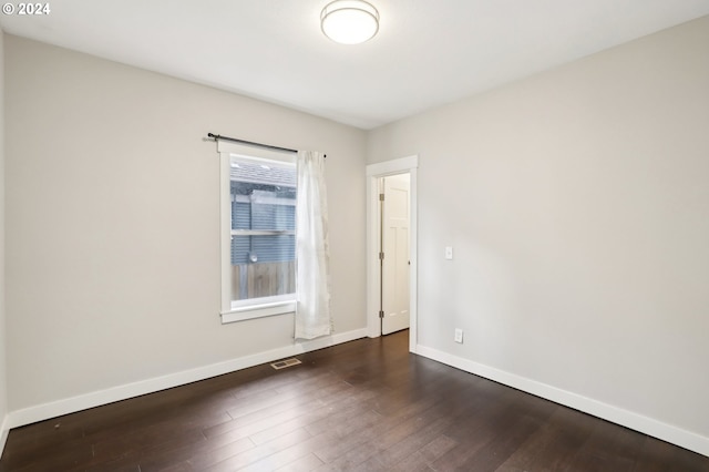 unfurnished room featuring plenty of natural light and dark hardwood / wood-style flooring