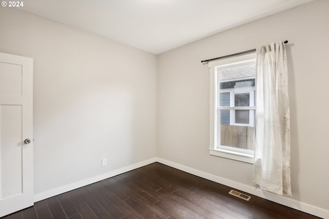 empty room with dark hardwood / wood-style flooring