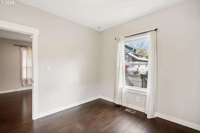 unfurnished room with dark wood-type flooring