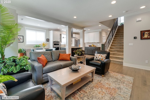 living room featuring crown molding, recessed lighting, stairs, wood finished floors, and baseboards