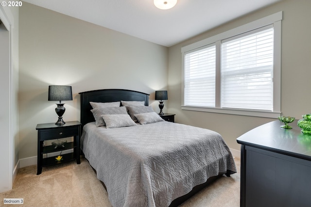 bedroom with light carpet and baseboards