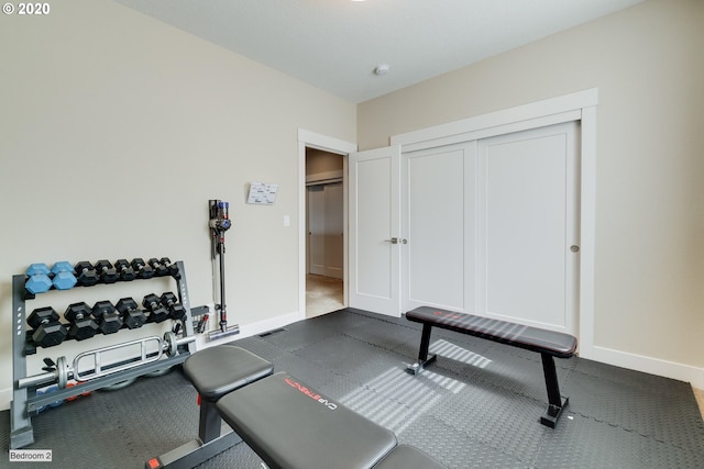 workout area featuring baseboards and carpet floors