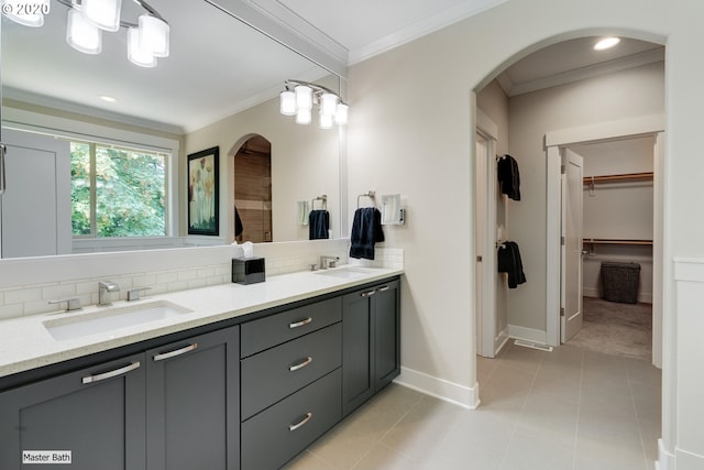full bath with crown molding, decorative backsplash, baseboards, a walk in closet, and tile patterned flooring