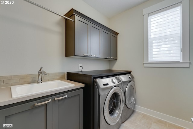laundry room featuring cabinet space, washing machine and dryer, baseboards, and light tile patterned floors