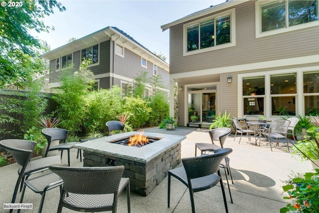 back of house with an outdoor fire pit and a patio area