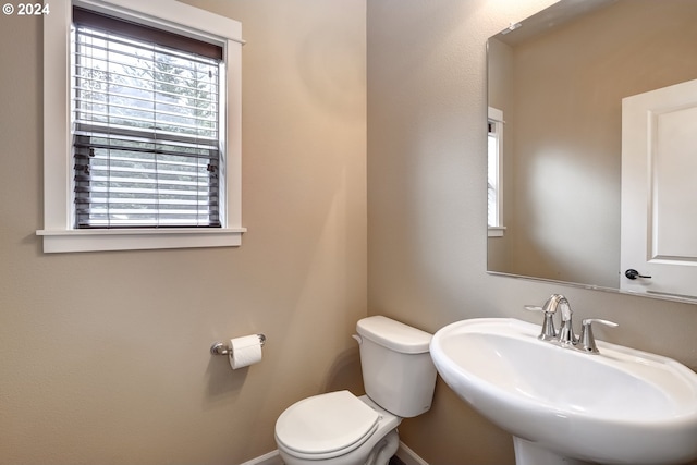 bathroom featuring a healthy amount of sunlight, sink, and toilet