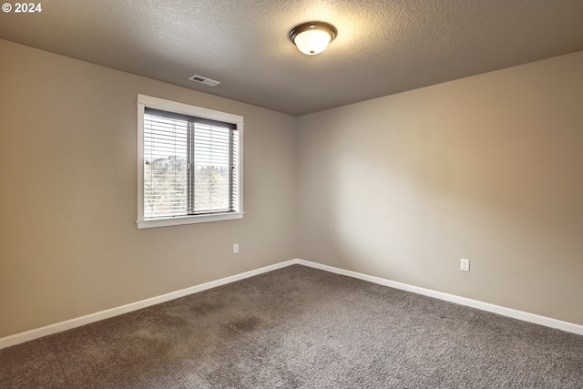 carpeted empty room featuring a textured ceiling